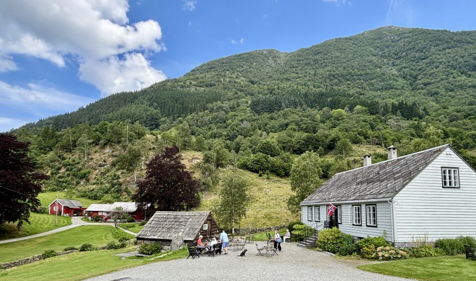 Det kvite vestlandshuset er flytta opp frå Rosendal og gjort om til kafé. Den raude hytta i bakgrunnen var i si tid utleigehytte, men tener i dag som kårhus.