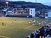 Spelarar samlar seg i feltet under ein corner på ein kveldskamp med publikum på tribunen.